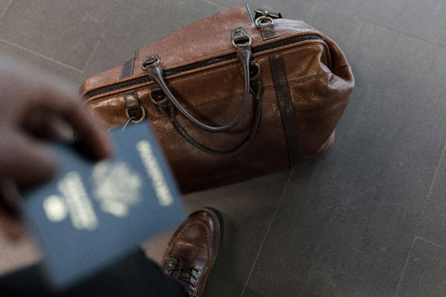 Brown duffel bag and passport 